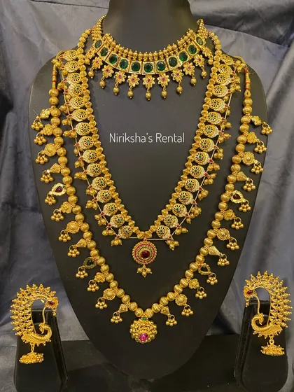 A full bridal set with green stone accents, including a choker, a medium necklace, and a long haram.