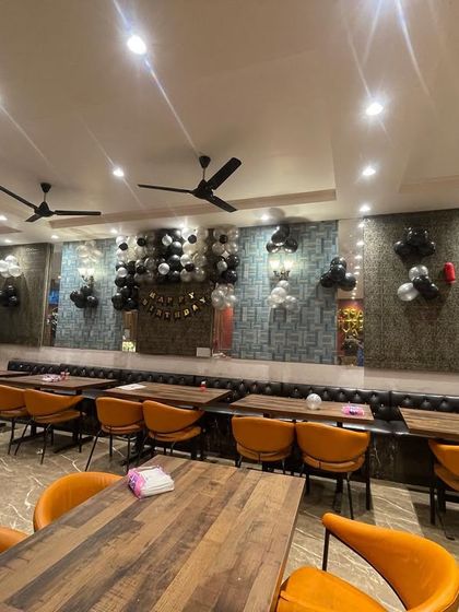 Simple balloon decorations can make a big difference in a restaurant setting. Here, I used black, white, and silver balloon bunches to decorate the walls for a birthday party.