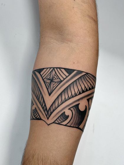 A Maori-style armband tattoo. These designs are rich in cultural symbolism, representing strength, family, and heritage. This piece has clean lines and traditional patterns.