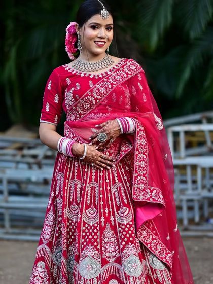 A smiling bride in a vibrant pink lehenga, perfect for a day wedding. The silver embroidery adds a touch of modern elegance.