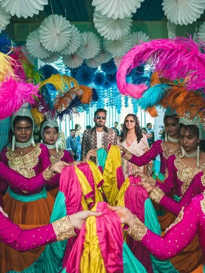 The dancers create a welcoming formation for the couple. The coordination of costumes and choreography makes for a visually spectacular entry.