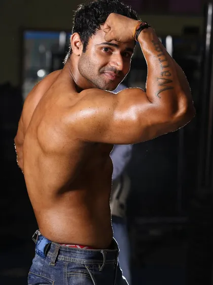Building an impressive physique requires attention to detail. This back-double-bicep pose showcases the muscle definition and symmetry that I help my athletes develop for competition.