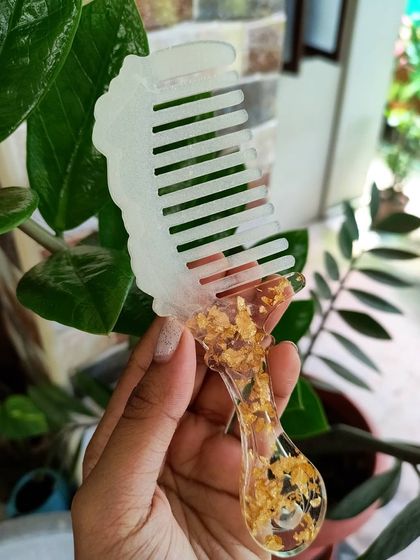 This resin comb has a more modern look, with a white top and a handle filled with shimmering gold flakes.