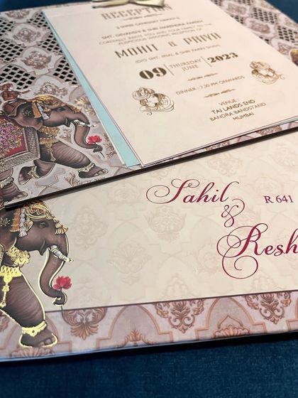A close-up of an invitation suite with elephant motifs, showing the matching envelope and inserts for the reception.