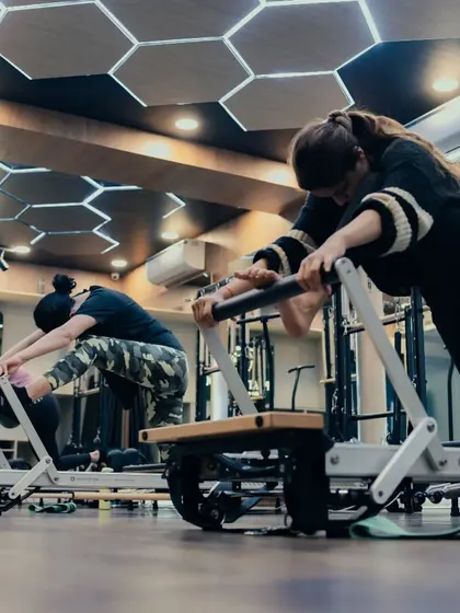 A full class works on a lunge variation. The reformer adds resistance and challenge, helping everyone to build lower body strength and improve their balance together.