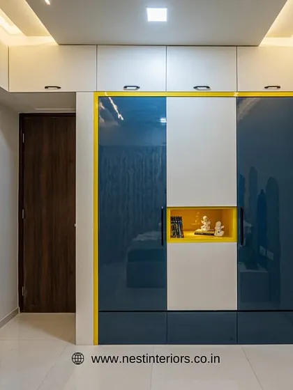 The wardrobe in this kid's room features a bold color-block design in blue, white, and yellow. The small niche in the center is perfect for displaying favorite toys or treasures.