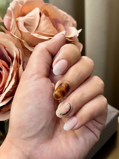 Birthday nails, but make them extra. This design features a mix of ombré, tortoise shell, and gold chrome accents for a look that's perfect for celebrating.