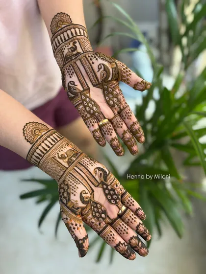 This elegant design features peacocks and elephants, classic motifs in Indian bridal mehendi. The composition is balanced and leaves some skin showing for a lighter feel.