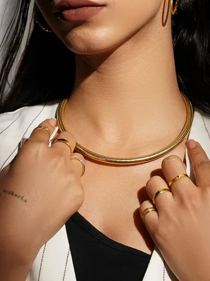 A close-up on the details. Our bold gold choker and minimalist rings are designed to enhance your unique style.