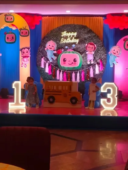 A vibrant and fun Cocomelon-themed birthday stage, one of our most requested designs for kids. This large-scale setup includes multiple character cutouts, themed arches, a central grass-wall backdrop, and large, illuminated marquee numbers for the age.
