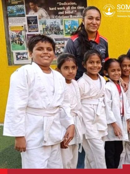 Our youngest female judo athletes with their coach, smiling after their medal-winning performances.