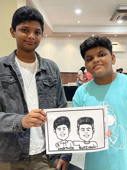 The same two friends, Karthik and Sufiyan, posing with their caricature at the school event. It's always fun to see their reaction.