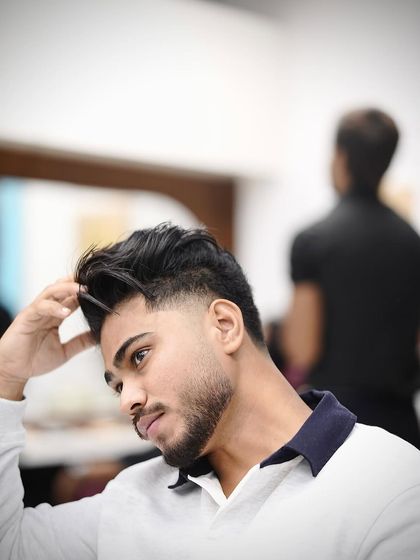 He's checking out his new taper fade. The lines are incredibly sharp, and the fade is seamless.