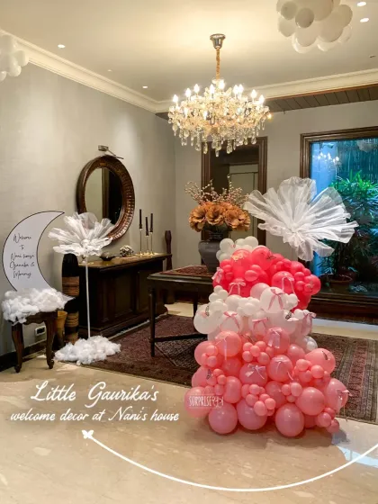 There's nothing like a homecoming celebration at Nani's house. For little Gaurika, I created this cozy and elegant welcome decor, using soft pink balloons, dreamy cotton clouds, and a personalized moon sign to make her first visit feel extra special and full of love.