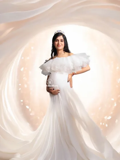 A swirl of light and fabric. This abstract portrait uses creative lighting and flowing white drapes to create a beautiful, glowing tunnel effect around the expectant mother.