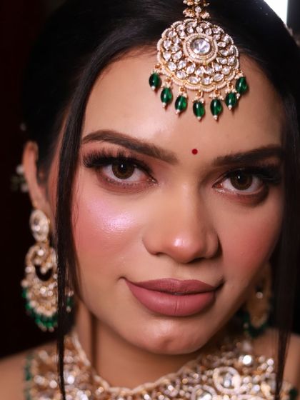 A close-up of the elegant royal bride, highlighting the flawless skin finish and the precision of the eyebrow and lip work.