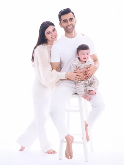 Our timeless all-white studio style is perfect for creating modern, clean, and elegant family portraits. By keeping the background and wardrobe simple, we ensure that the love and connection between this family of three remain the central focus.