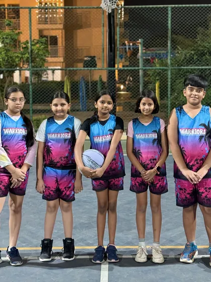 The girls' Warriors team ready to hit the court. They are dressed for success in their unique and vibrant team jerseys.