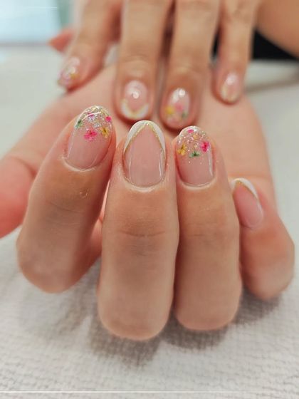 A delicate and feminine design perfect for any occasion. This nail art features tiny, colorful flowers scattered across the tips with a hint of glitter for a subtle sparkle.