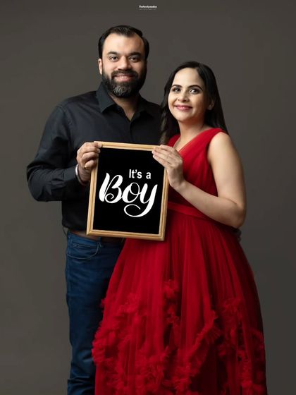 A happy couple announces "It's a boy!" with a custom sign during their studio maternity session. We have a variety of props available to help you share your exciting news.