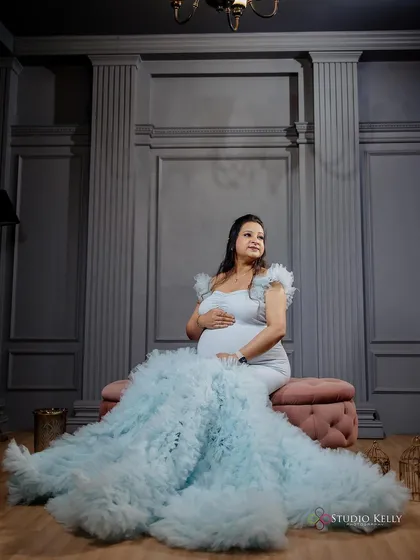 An ethereal maternity shot with the client in a flowing light blue gown. The makeup is soft and dreamy, complementing the angelic vibe of the photo.