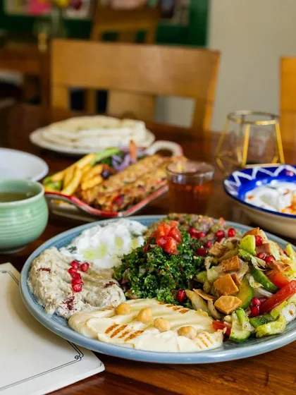 A wider angle of the food spread at Cafe Zubaan. This image captures the ambiance of the cafe, showing the food in the context of the restaurant's environment.