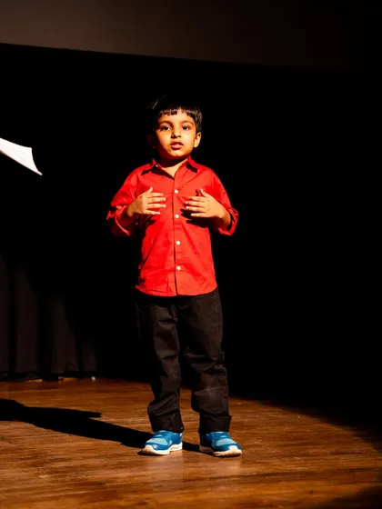 A young actor under a spotlight, showing the courage it takes to stand alone on stage and perform.