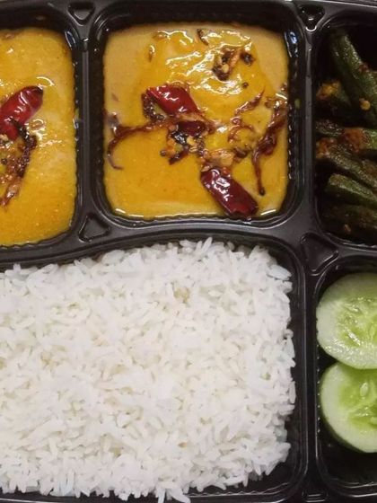 Enjoy the simple comfort of a home-cooked meal with our vegetarian tiffin service. This thali includes steamed rice, flavorful dal tadka tempered with spices, and a delicious bhindi fry (okra).