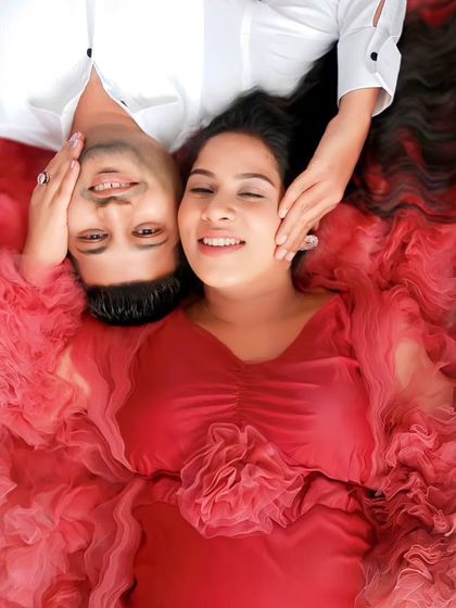 This creative overhead shot showcases the beautiful texture and volume of our wine-red ruffled gown, creating a bed of flowers effect.