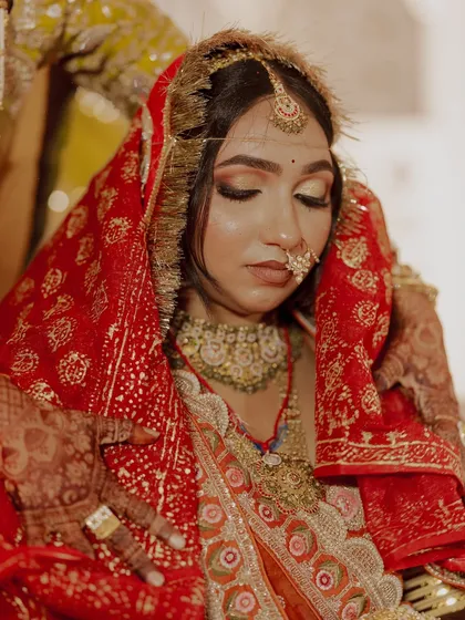 A serene moment showing the detailed eye makeup with a golden shimmer and winged liner, perfect for a traditional ceremony.