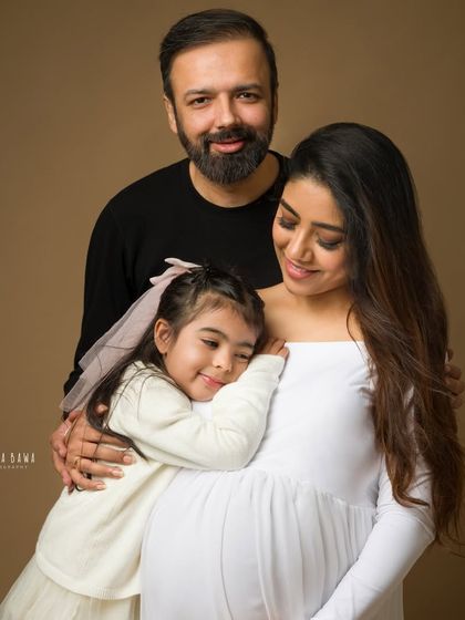 A loving family embrace during a maternity session. The daughter snuggles close, creating a portrait that is both intimate and beautiful.