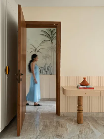 A person walks past the open door of the master bedroom, giving a sense of movement and life to the beautifully designed home.