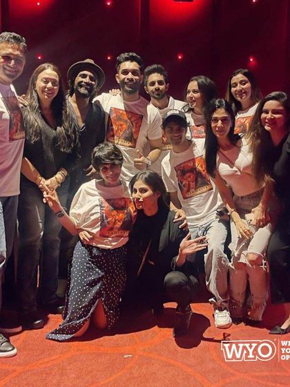 The entire group posing at the movie theatre in their custom Brahmastra fan t-shirts.