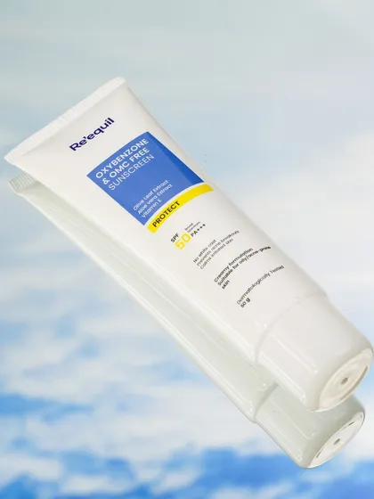 A creative practice shot using a mirror to reflect a cloudy sky, making the sunscreen tube appear to float. This technique creates a dreamy, ethereal visual that highlights the product's protective qualities.