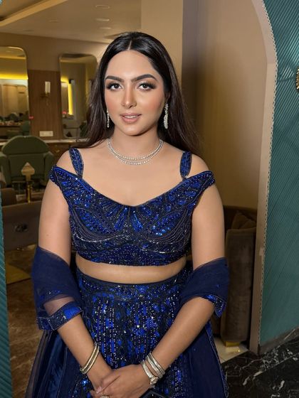 This client looks absolutely radiant. The soft glam makeup is perfect for her elegant off-the-shoulder lehenga.