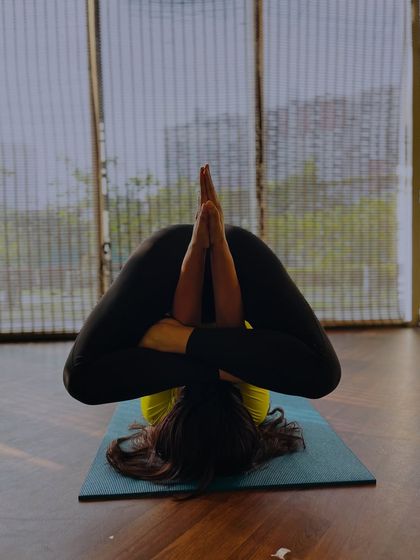 An advanced shoulder pressing pose, demonstrating incredible flexibility and control. This is the result of dedicated and patient practice over time.
