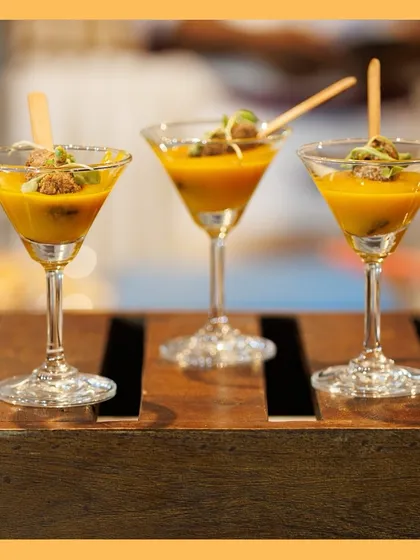Three martini glasses holding our Thai fritter and mango coulis appetizer, ready to be served to guests. A perfect example of our elegant canapés.