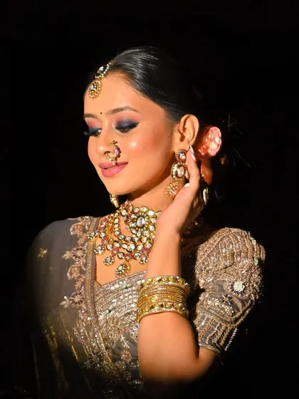 Another beautiful shot of the grey saree look, captured in dramatic lighting that highlights the makeup and jewelry.