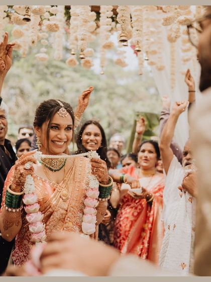 The bride's joyful expression as she holds up the Varmala, ready for one of the most fun parts of the ceremony.