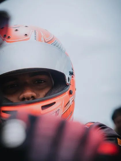 An intense close-up of a driver's eyes through his helmet visor.