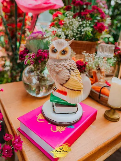 Another adorable prop, this wise owl figurine perched on a stack of books, adds a touch of whimsy and charm to the vibrant Mehendi decor.