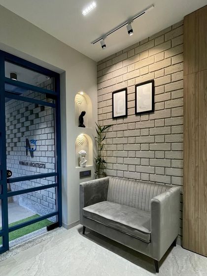 The entrance and waiting area of our studio. We used an exposed brick wall, a comfortable velvet sofa, and arched niches to create a warm and welcoming first impression for our clients.