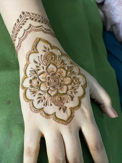 A random click of this lovely floral motif on the back of the hand. The scalloped border and delicate wristband add a touch of elegance to the central flower.