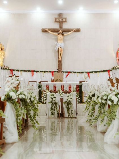 The view down the aisle towards the beautifully decorated altar. The symmetry of the floral arrangements creates a sense of harmony and reverence, perfectly suited for a church ceremony.