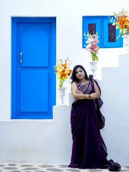 A full-length shot showcasing a beautiful purple gown against the clean white and blue of our Santorini set.