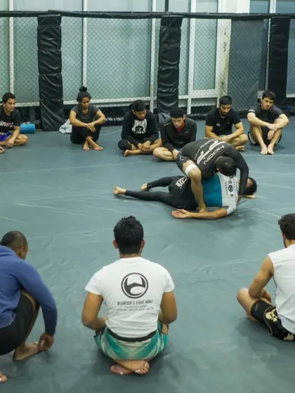 A seminar is a classroom where the subject is combat. Here, students observe a live demonstration, absorbing the details of a Jiu-Jitsu technique before drilling it themselves. This focused learning is key to preparing for competition.