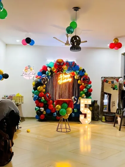 A wide view of a superhero-themed birthday party setup in a living room, showing the full scale of the decoration.