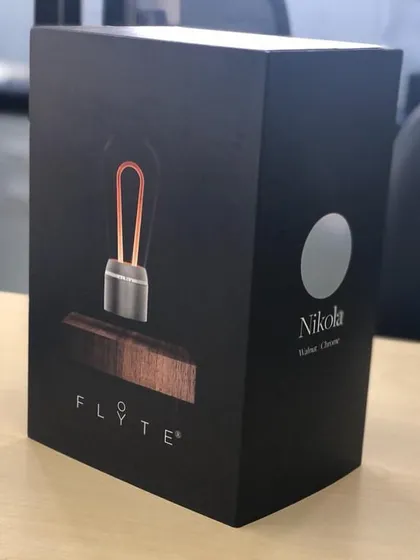 The FLYTE Nikola levitating bulb features a distinctive chrome cap and a filament design inspired by Nikola Tesla. The product is presented in a sleek black box, perfect for gifting.
