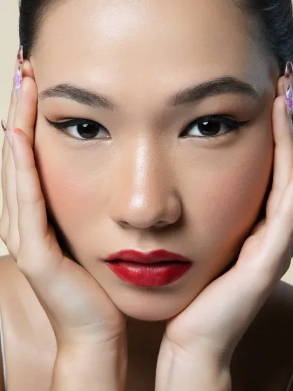 A perfect winged liner and a bold red lip are a classic combination for a reason. This close up shows the precision of the sharp cat eye, the rich pigment of the lip, and the smooth, perfected skin that serves as the ideal canvas.