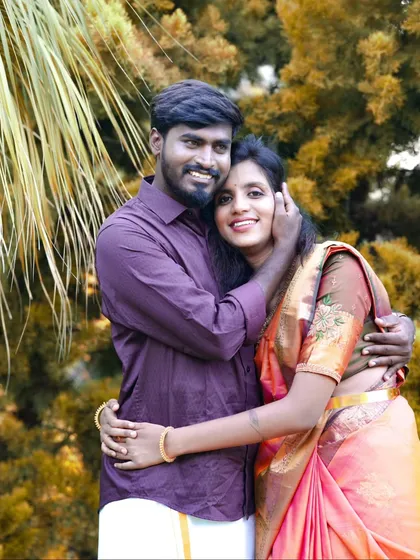 A happy, close-up portrait of the couple. The groom is wearing a dhoti and the bride is in a beautiful saree, perfect for a traditional pre-wedding album.